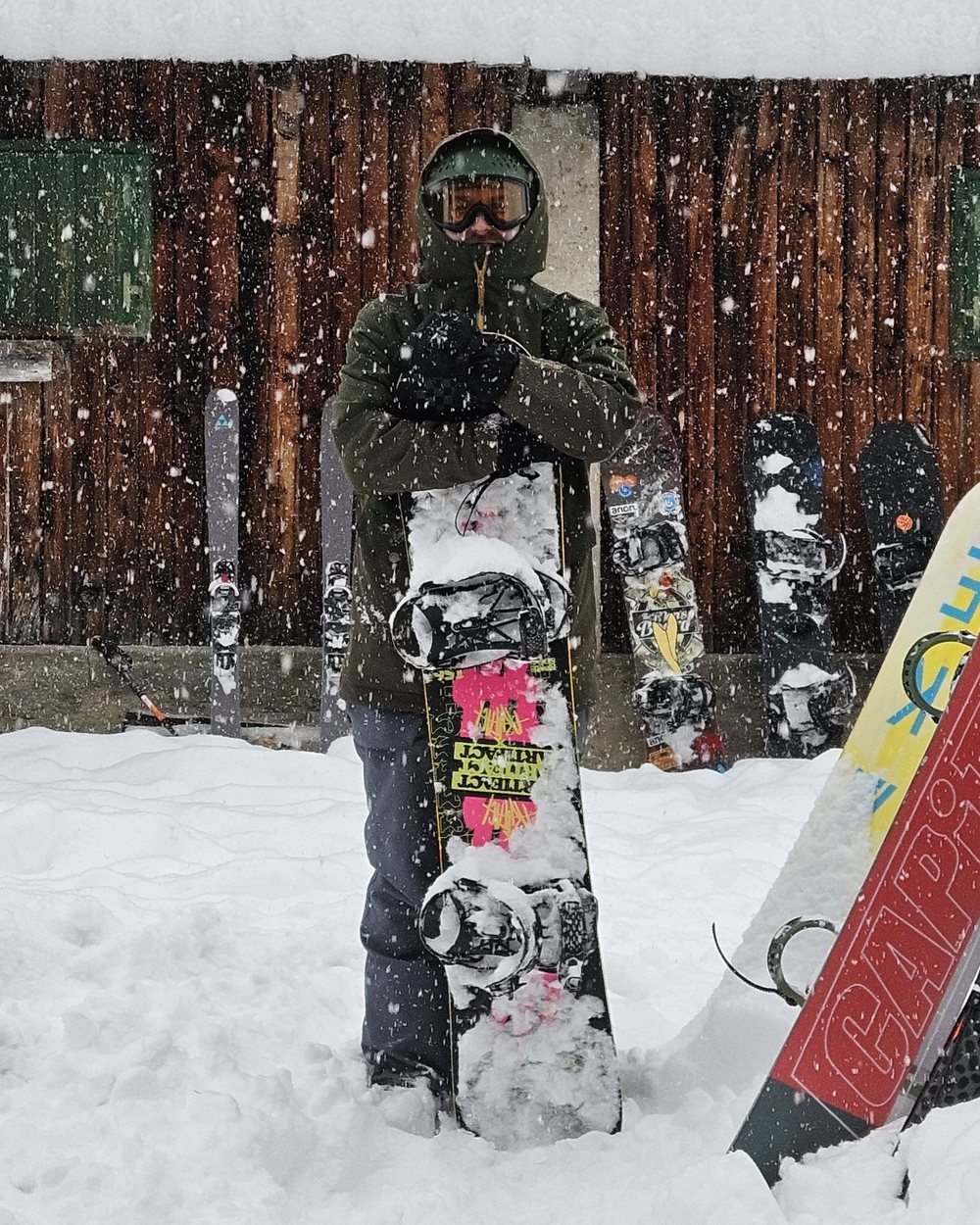 Gianluca Candosin with his snowboard, in heavy snowfall outside a mountain hut
