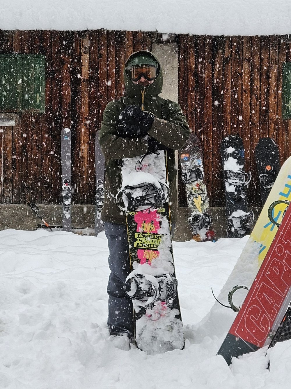 Gianluca Candosin with his snowboard, in heavy snowfall outside a mountain hut