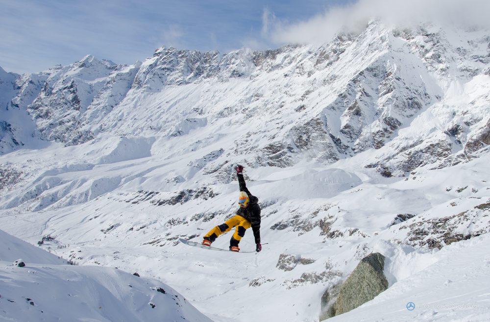 Snowboarder jumping between rocks and fresh snow, November 2019