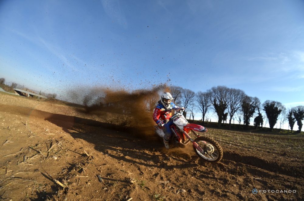 Motocross, rider sliding and kicking up dirt, January 2014